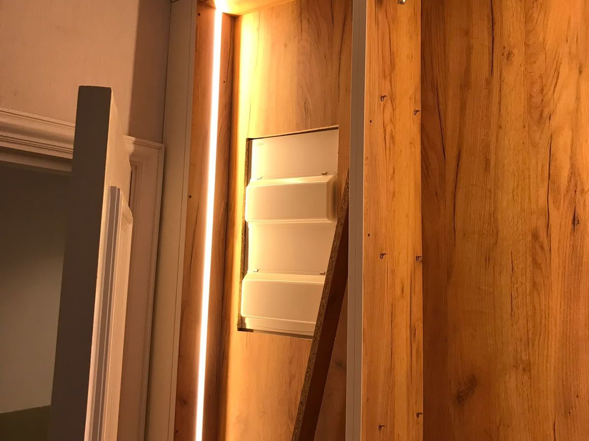 Consumer unit recessed into fitted joinery with concealed LED strip lighting